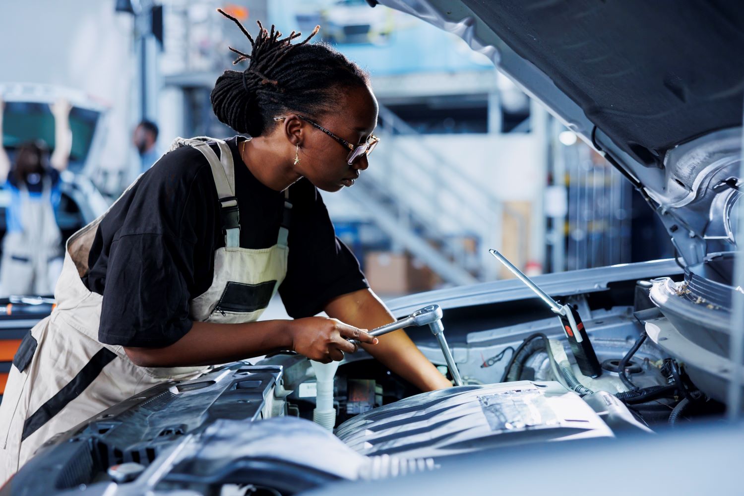 worker examines out order car engine.jpg